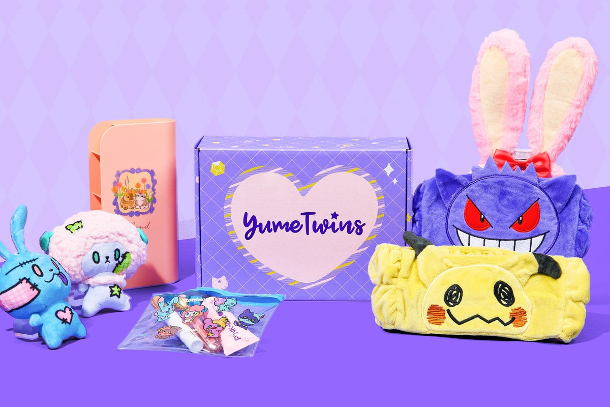 A purple YumeTwins box with its heart logo, surrounded by the October 2026 Kawaii Monster Mash box items: Pokémon Gengar and Mimikyu headbands, a pink bunny-ear headband, zombie animal plushies, and a clear pouch