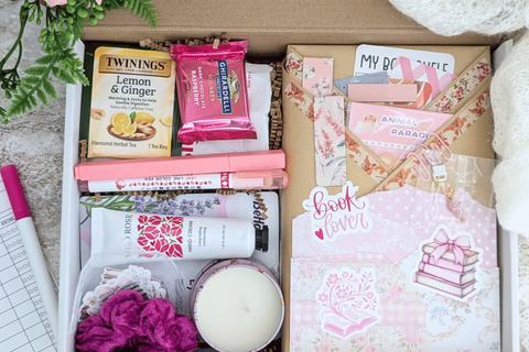 surprise book box with new book, annotation supplies, relaxation and self care items packaged neatly in a box