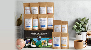 Bean Box's World Coffee Tour gift box with a stack of Bean Box coffee bags from independent roasters