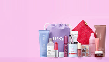 IPSY’s purple drawstring bag with the IPSY wordmark, surrounded by full-size beauty products including a Fenty Hair tube, The Ordinary serum, a Benefit mascara, First Aid Beauty cream, and a Wingme eyeshadow palette, on a pink background