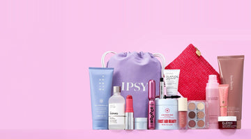 IPSY’s purple drawstring bag with the IPSY wordmark, surrounded by full-size beauty products including a Fenty Hair tube, The Ordinary serum, a Benefit mascara, First Aid Beauty cream, and a Wingme eyeshadow palette, on a pink background