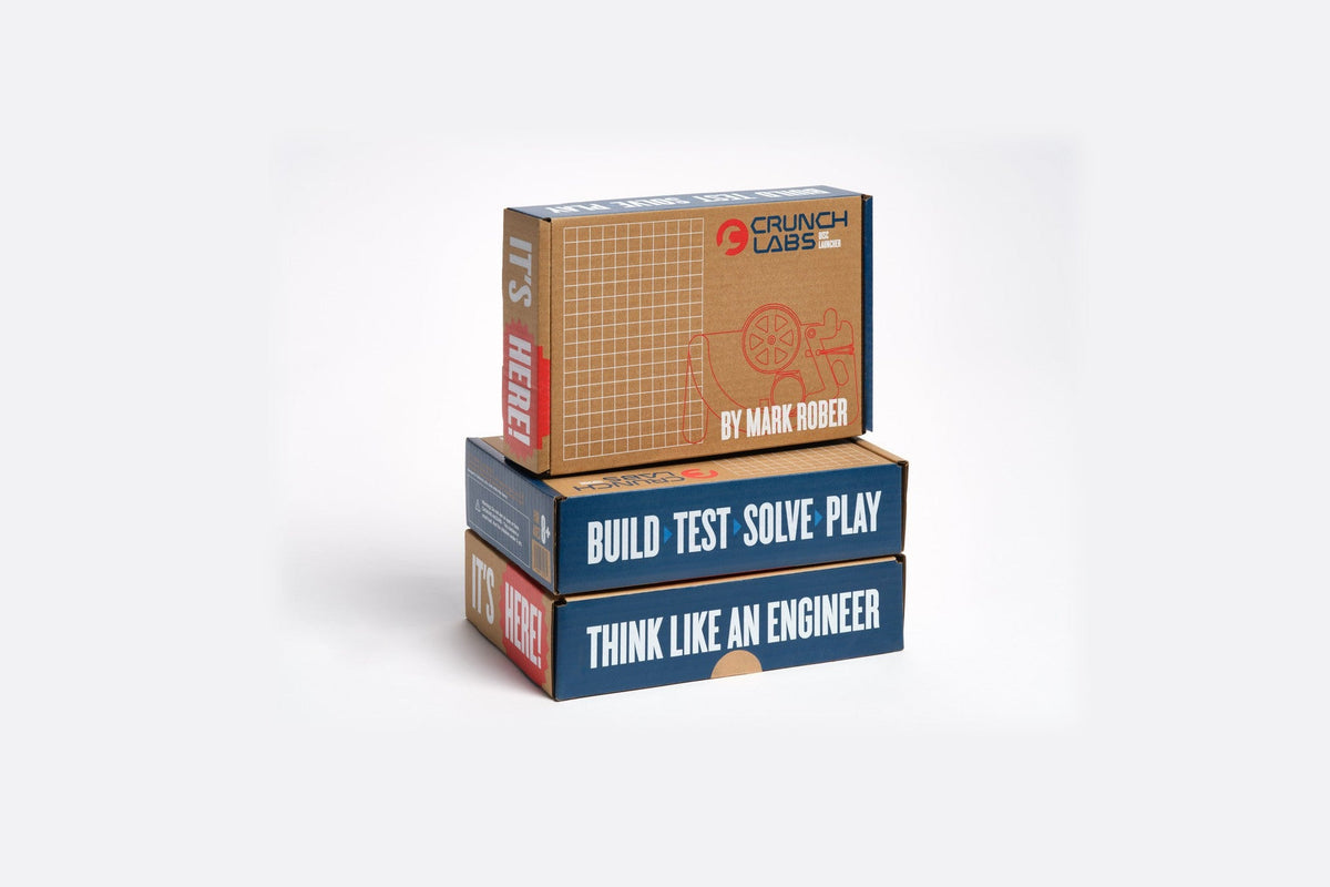 Three CrunchLabs Build Boxes stacked on a white background, the top box printed with the CrunchLabs logo and “By Mark Rober,” the lower two with “Build, Test, Solve, Play” and “Think Like an Engineer”