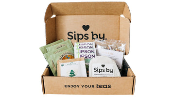 An open Sips by discovery box holding four teas from different tea brands and a Sips by muslin tea bag