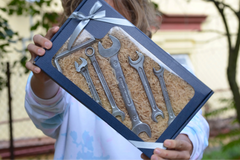 Lifestyle photo of a girl holding our box filled with chocolate wrenches, hex keys, and realistic tool-shaped sweets