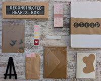Contents of the Deconstructed Hearts Box including paper bundle, greeting cards, heart cutouts, envelope seals, foam pop dots, and an easel.
