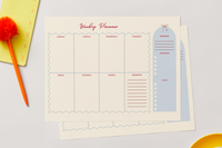 Weekly Planner notepad sheets with a space for each day, a priorities list, and a to-do column, next to an orange pen
