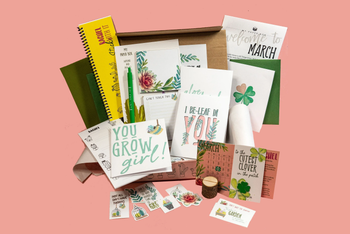 Plant-themed stationery flat lay with “You Grow Girl” and “I Be-Leaf in You” designs from My Paper Box March box, featuring cactus art.