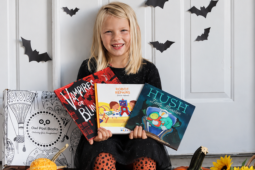 Child holding three books from her Owl Post Books kids book club surrounded by pumpkins and Halloween decorations