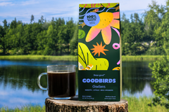 cup of coffee and bag of coffee on a stump in nature, part of Goodbirds monthly coffee subscription of 2 12oz bags of coffee