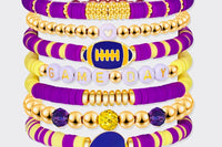 Game Day 8-piece stackable friendship bracelet set in purple, yellow, and gold beaded colors with a football charm, a helmet charm, and GAME