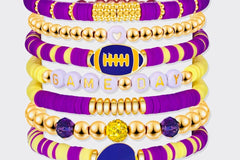 Game Day 8-piece stackable friendship bracelet set in purple, yellow, and gold beaded colors with a football charm, a helmet charm, and GAME