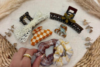 a close up of a fall box example of curated hair accessories. shown are brown and cream tones for fall.