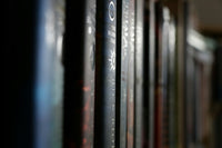 Very high quality close-up photo of a bookshelf with many old and expensive books that are stacked next to each other.