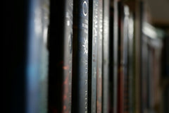 Very high quality close-up photo of a bookshelf with many old and expensive books that are stacked next to each other.
