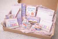 Book lovers stationery box with notepads, bookmarks, stickers, tabs and an ink pen arranged neatly in a box lined with tissue paper.