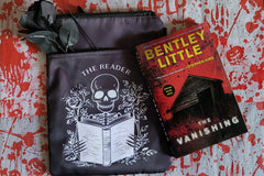 This is The Vanishing by Bentley Little on a bloody handprint backdrop with a zippered book cover  with a skeleton reading a book on front