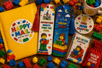 Colorful building-block inspired bookmark subscription featuring two playful reading bookmarks, matching sticker, yellow package, and book