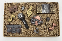 Box containing chocolate creations for music lovers, including microphones, musical notes, radios, and themed sweet treats
