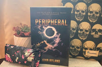 Book titled Peripheral by John Ryland, with two gifts: a flowered glass case and a book cover with skull in rows, and a small pink potted pl