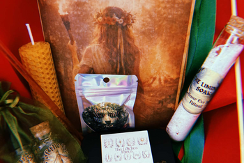 A collection of ritual items from the Busy Witch Box, featuring candles, herbs, and a ritual guide for Sabbat practices