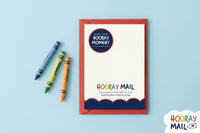 Back of a colorful Hooray Mail card layered on top of a red envelope with colorful crayons on the left.