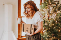 A hand pours tea from a kettle into a cup beside a Tea Runners subscription box and loose leaf tea packages