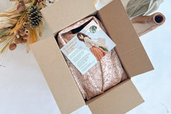 a box of thrifted vintage clothing, an entire outfit in a box with a welcome letter explaining our styling service