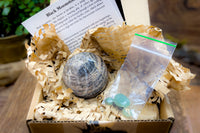 Open box example of Enchanted Crystal subscription box, with single featured crystal and all recycled or recyclable packaging 