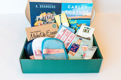 Box of Books subscription box featuring two novels and skincare items like Make Up Eraser and Sock it to Me