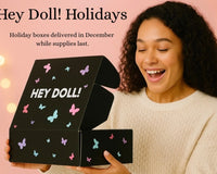 Hey Doll! holiday box promotion with silver, white, and navy ornaments. Ships in December while supplies last.