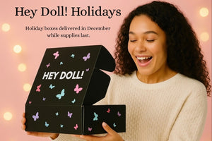 Hey Doll! holiday box promotion with silver, white, and navy ornaments. Ships in December while supplies last.