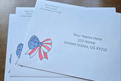 Three white envelopes with printed sample U.S. addresses and red, white and blue patriotic bow designs featuring stars and stripes.