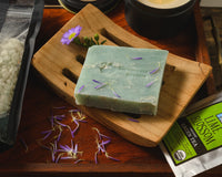 Introverts Retreat box items including bath salt soak, a candle, tea, and a homemade greenish bar of soap.