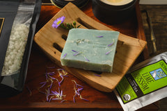 Introverts Retreat box items including bath salt soak, a candle, tea, and a homemade greenish bar of soap.