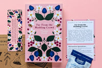 A hand holds three colorful Jane Austen book covers in a cozy setting, part of the TEA & BOOK CLUB subscription box for book lovers