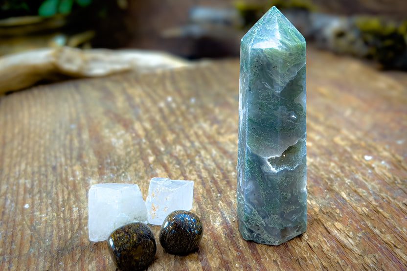 Enchanted Crystal subscription box on wooden table, with single featured crystal of the month and bonus mini crystals