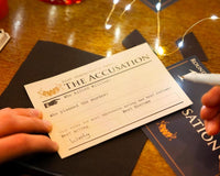 Close up photo of a persons hands holding a pen and a piece of paper with the words accusations and many more.