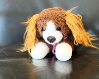 A head shot of the snorri stuffed animal. You can see her light brown ears, brown and white face, brown eyes and nose. 