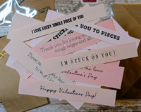 Pink paper strips all spread out so you can read the inside card sayings printed on them, including I'm stuck on you & Happy Valentine's Day