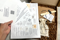 What is inside the box on top of the Lesson packets. Includes bag of paint, branded sketchbook, black painter's tape and sticker and more!