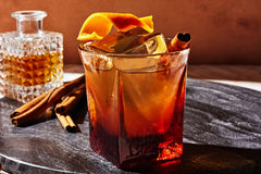 Classic Old Fashioned cocktail with an orange peel garnish, luxury cherries, and a crystal-clear ice
