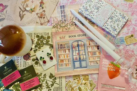 mushroom mug, tea packets, face mask, white candlesticks, strawberry earrings, strawberry face mask, notebook, cottagecore print, bookmarks