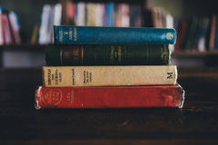 A person holding an open hardcover book with red edges, showcasing a cozy reading moment for book lovers with the Fantasy Books Club subscription