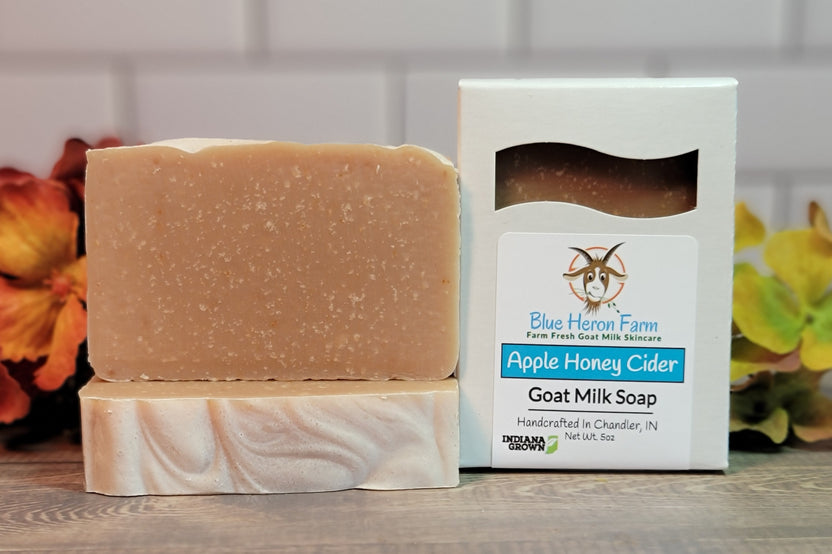 Three bars of Apple Honey Cider goat milk soap. Two are stacked and one is in a box surrounded by fall foliage.