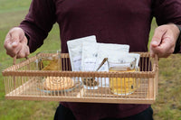 A hand pours tea from a kettle into a cup beside a Tea Runners subscription box and loose leaf tea packages