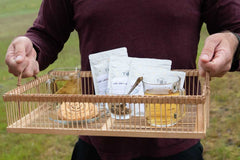 A hand pours tea from a kettle into a cup beside a Tea Runners subscription box and loose leaf tea packages