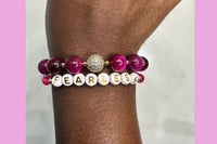 Handmade encouragement bracelet with soft pink stone beads, rose faux crystal accents, and white letter beads spelling “FEARLESS” 