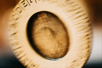 Close up blurred photo of a spinning coin that is a part of an escape mystery game. The coin is made from wood.