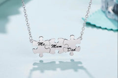 Silver puzzle necklace 3 piece pendants with each pendant inscribed with either “Mom, Dad or Me” each puzzle piece is held
Together  as one 