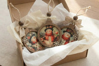Handcrafted vintage-style wooden ornaments featuring art paper designs, finished with rustic details